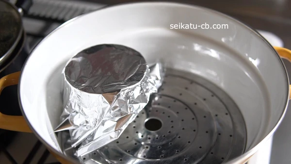 溶き卵を入れた容器にアルミニウムでふたをして蒸し器で蒸す