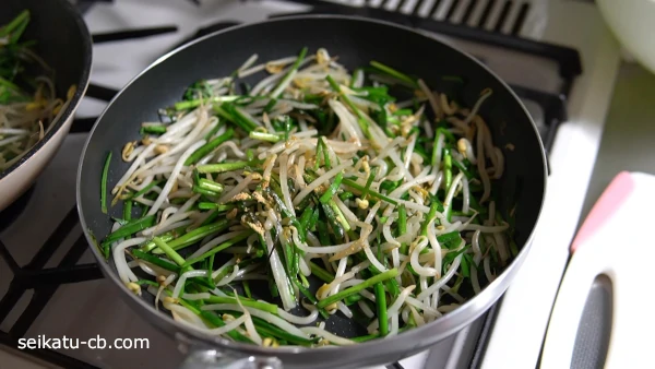 ニラともやしに調味料も加えて炒め合わせる