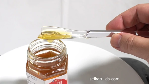 そのまま持っているとはちみつスプーンの底からはちみつが垂れてくる