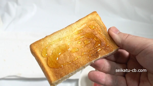 はちみつスプーンではちみつを塗ったトースト