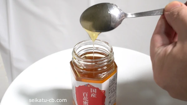 はちみつをすくったステンレススプーンを回転させる