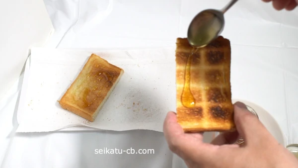 ステンレススプーンでトーストにはちみつを塗る