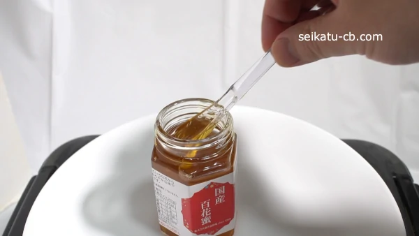 はちみつスプーンではちみつをすくう