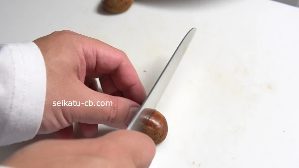 栗の側面に包丁で切込みを入れる