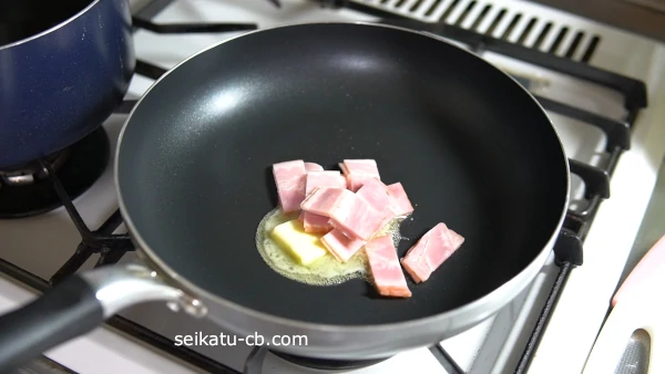 フライパンにバターを入れてベーコンを炒める