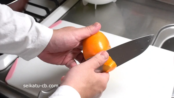 包丁で柿の皮をむく