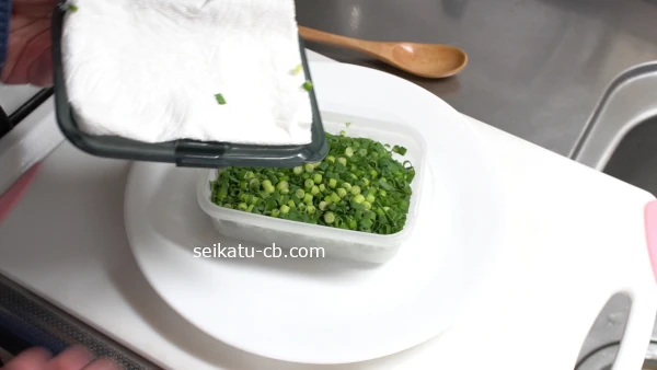 キッチンペーパーをのせて冷凍保存した刻みねぎとパックのふた