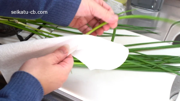 洗ったねぎを1本ずつキッチンペーパーで拭く