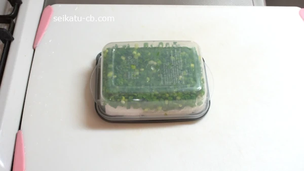 刻みねぎを入れ上にキッチンペーパーをのせたパックをひっくり返して冷凍保存