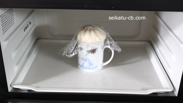 マグカップに肉まんを乗せてラップをしてレンジで加熱する