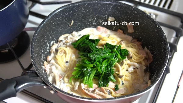 ゆでたパスタと煮汁に茹でたほうれん草を加える