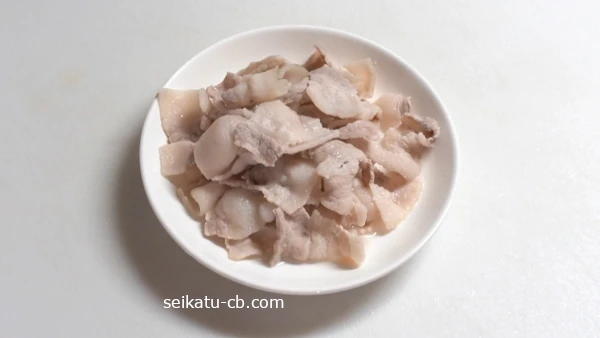 茹でた豚ばら肉を皿に取る