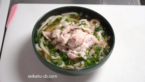 茹でたうどんに松茸の味お吸い物のスープをかけ豚肉と小口切りねぎを添える