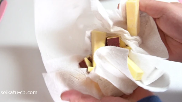 濡れたさつまいものスティックをキッチンペーパーで拭く